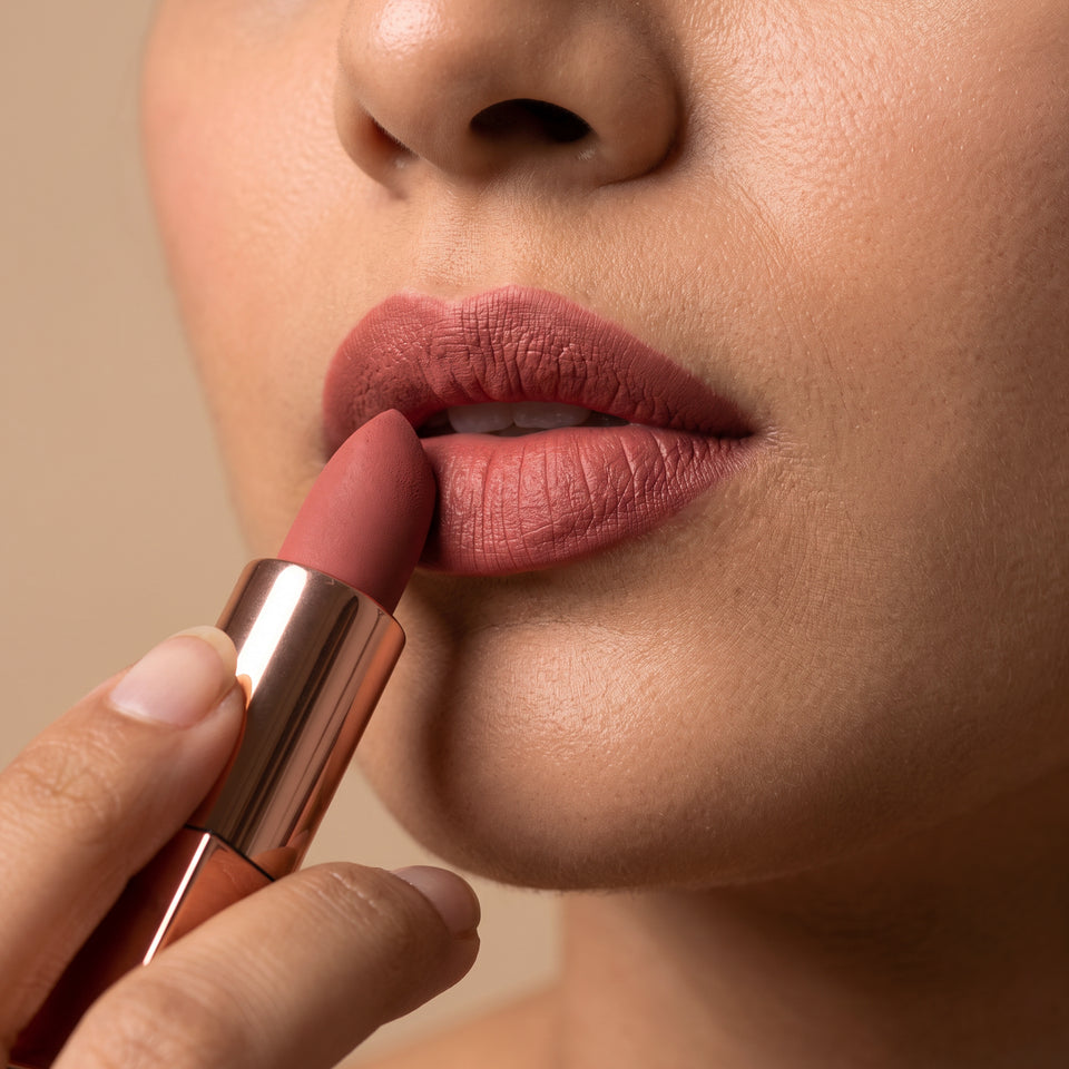 Applying a rose-nude creamy matte lipstick