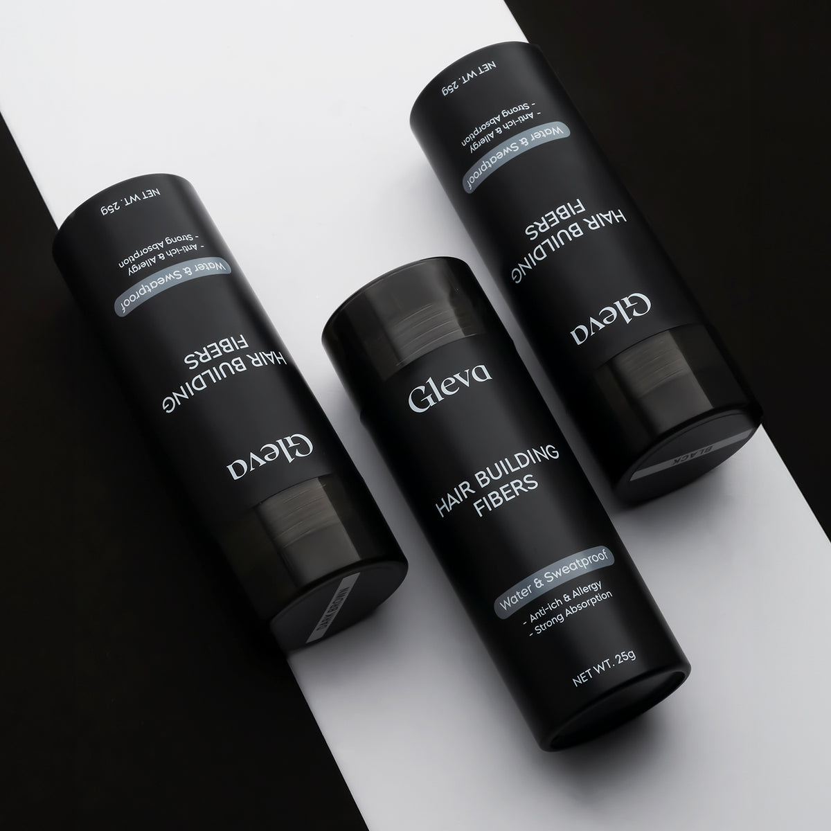 Three bottles of Hair Building Fibers on a black and white background